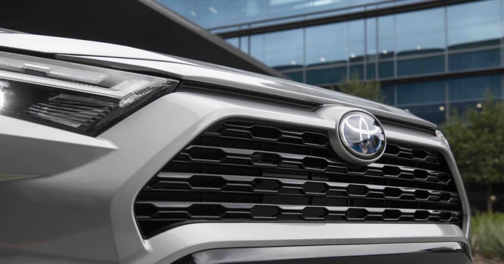Close-up of a silver Toyota vehicle's front grille, highlighting the design and logo, relevant to transmission issues in the UA80 model.