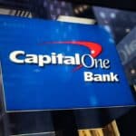 Capital One Bank sign displayed outdoors, featuring the bank's logo on a blue background, related to financial services and banking.