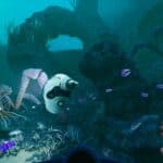 An underwater scene from Subnautica featuring a diver's hands exploring vibrant marine life and alien creatures.