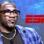 Shannon Sharpe in a blue checkered blazer speaking at a legal event, highlighting a lawsuit related to OnlyFans.